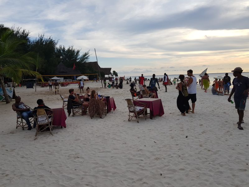 Dining tables laid on Nungwi Beach after the sun sets 日落后餐桌摆到沙滩