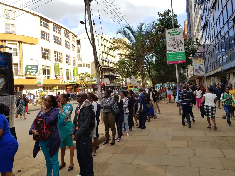 People queuing quietly for buses in the city center 人们排队候车