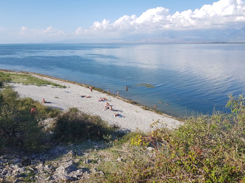 The few people at the shore enjoying the lake   在大湖岸上少见人影