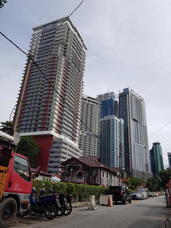 A Malay traditional house dwarfed by tall modern buildings in the city 市内高楼居高傲视脚下马来式房子