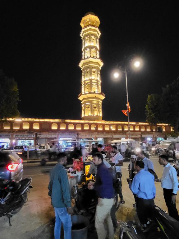 Locals enjoying hawker finger foods in front of Sargasuli Tower at night, built in 1749