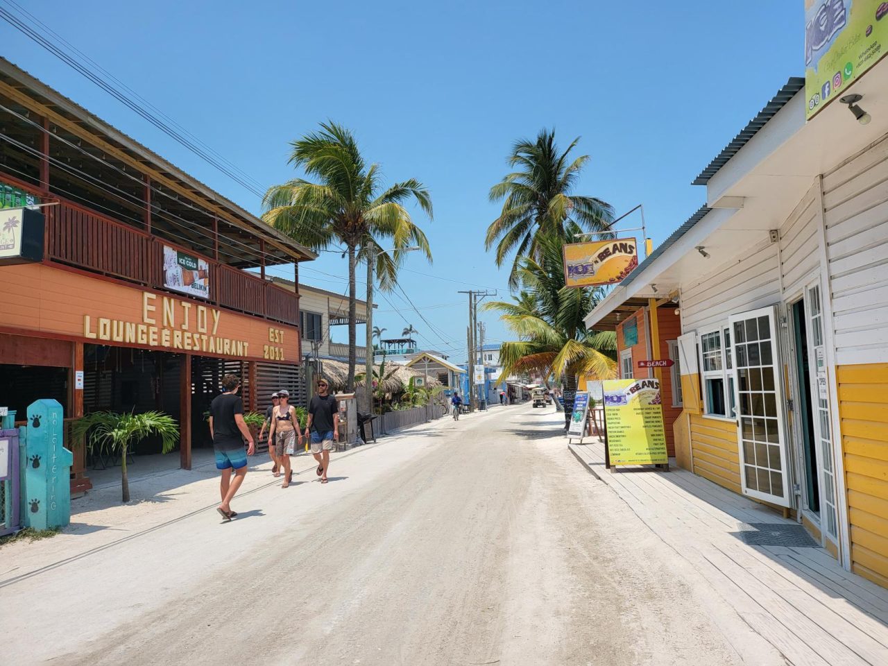 The shops and restaurants on white sandy streets in Caye Caulker