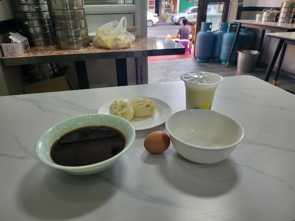 Basic traditional Chinese breakfast - black rice porridge, soya milk, steamed dumpling and boiled egg