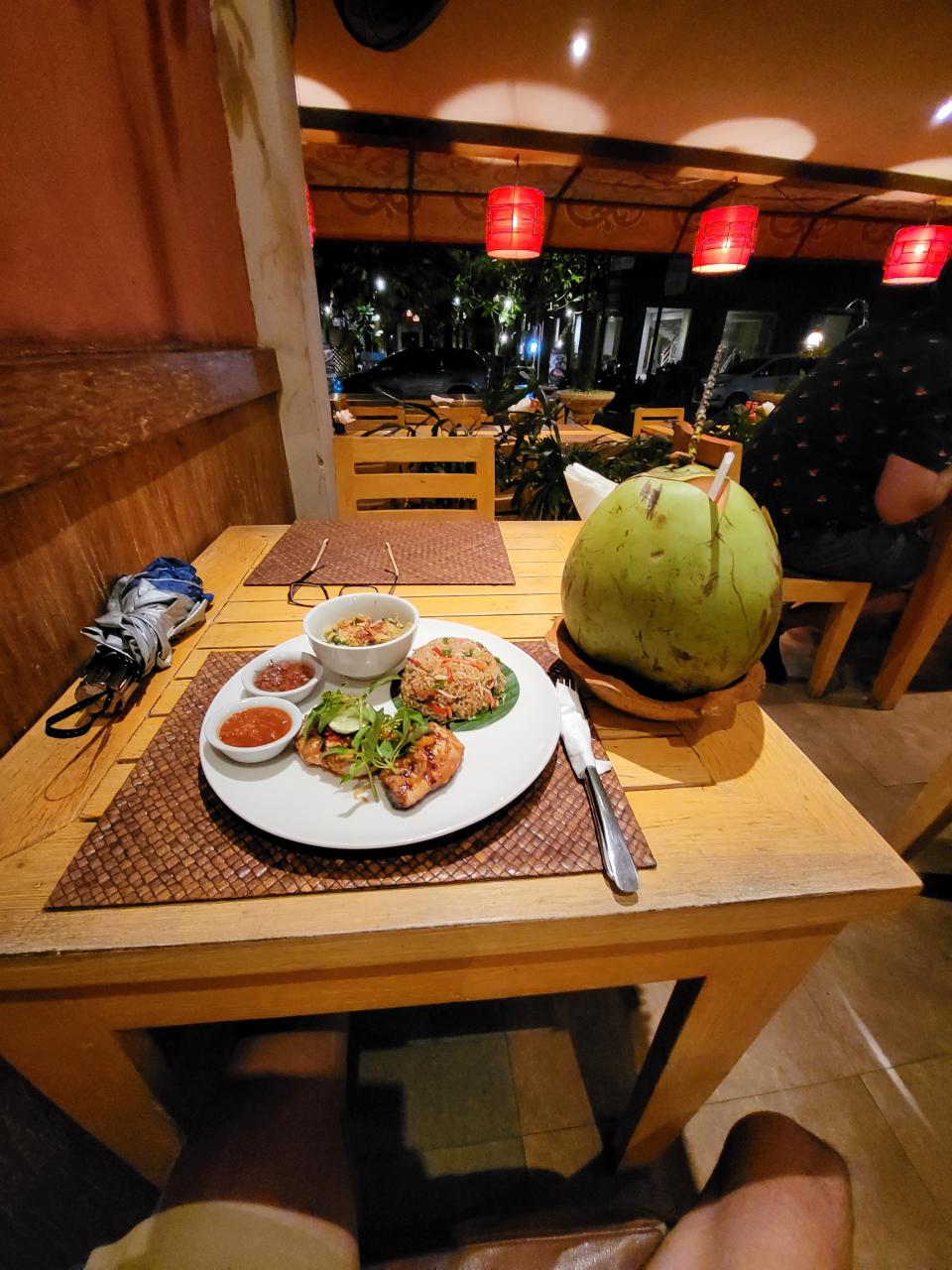 Indonesian dinner of grilled chicken and fresh coconut drink in Ubud, Bali