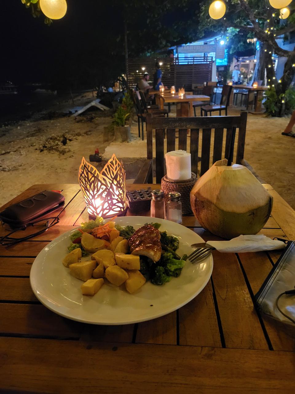 Dinner of fish steak and fresh coconut by the sea of Gili Trawangan