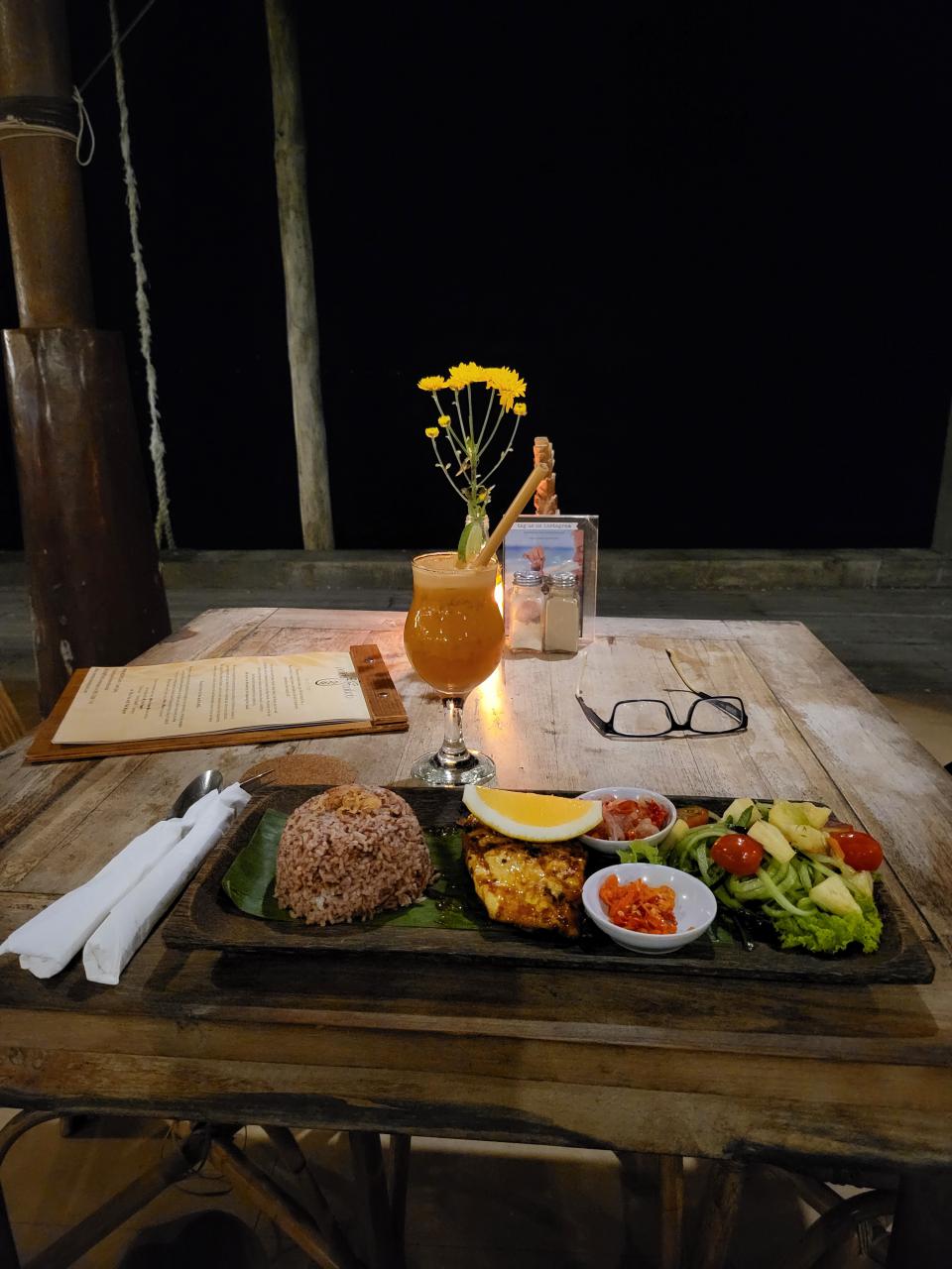 Romantic beachfront dinner alone - grilled fish and rice on a Nusa Penida beach